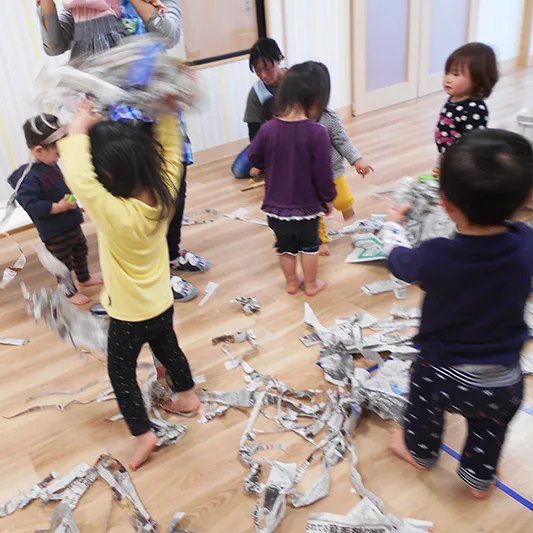みんなで新聞紙遊びを楽しむ子どもたち